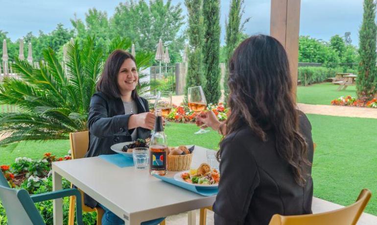 Due persone brindano all'aperto in un ristorante.