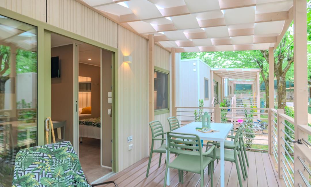 Modern terrace with table, chairs, and view of bungalows.