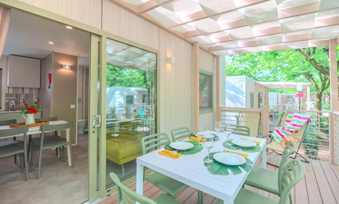 Moderne Terrasse mit Esstisch, Blick auf Innenraum und Garten.