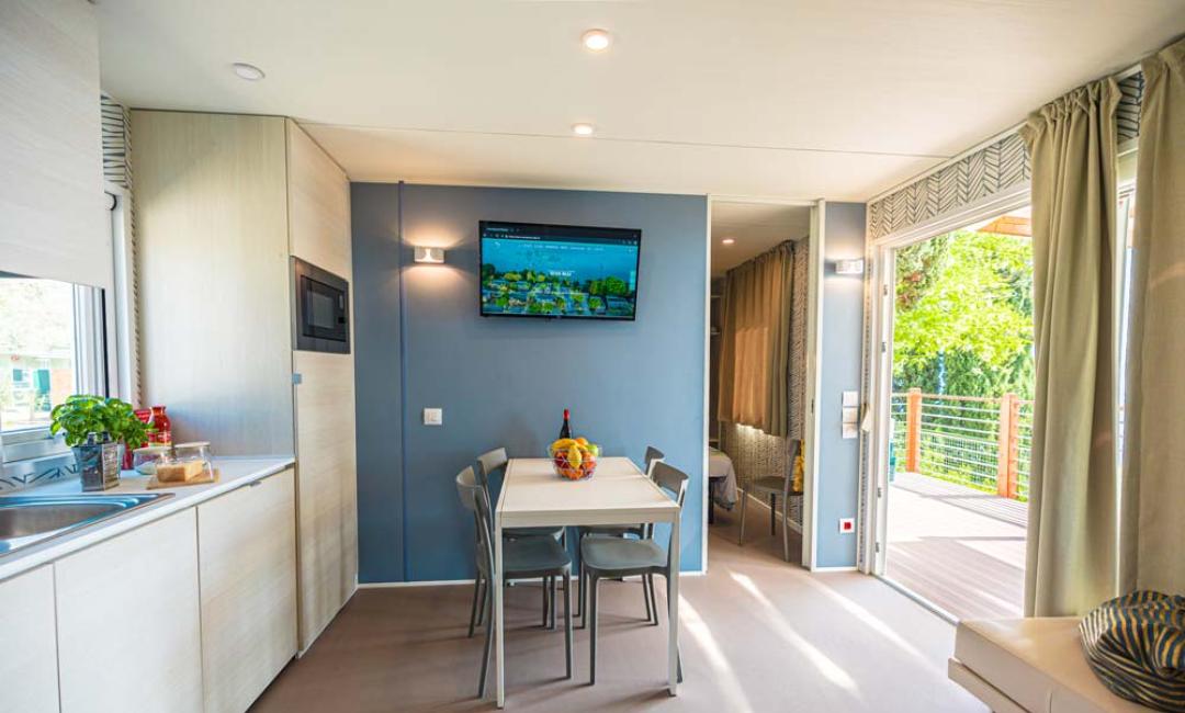 Appartement moderne avec cuisine, table à manger et balcon.