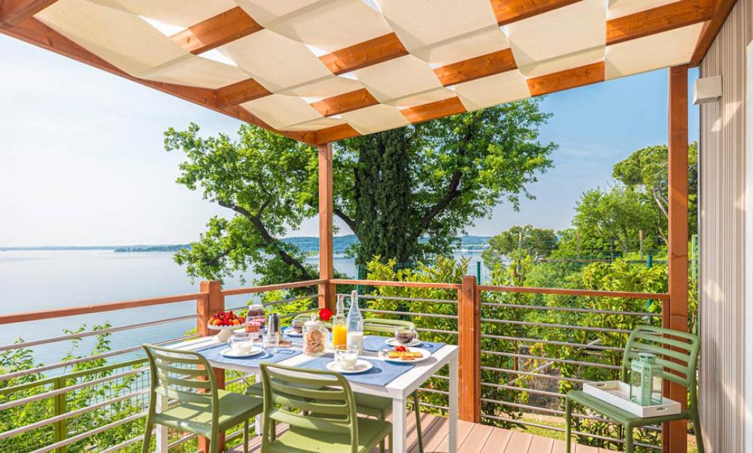 Terrazza con vista lago, tavolo apparecchiato per colazione.