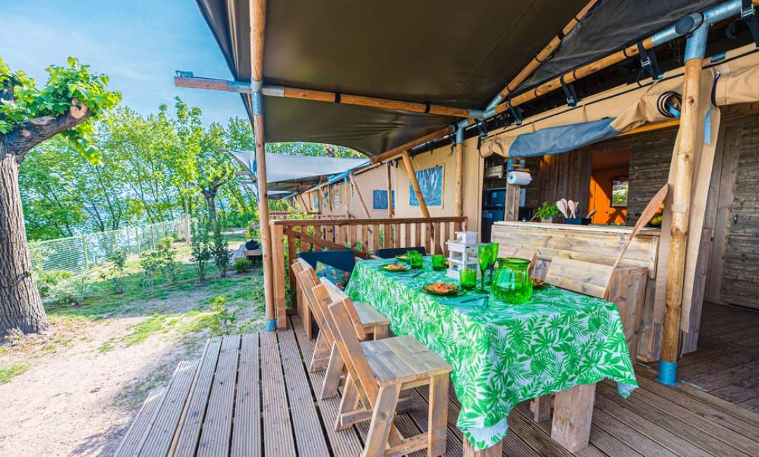 Terrazza all'aperto con tavolo apparecchiato, vista sulla natura.