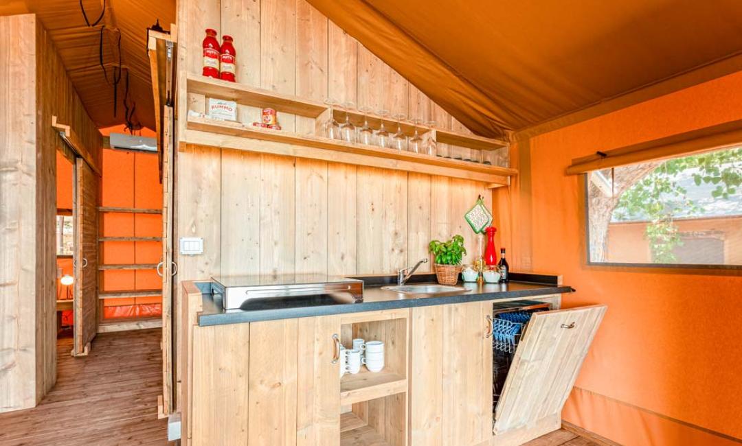 Rustic wooden kitchen with sink and open shelves.