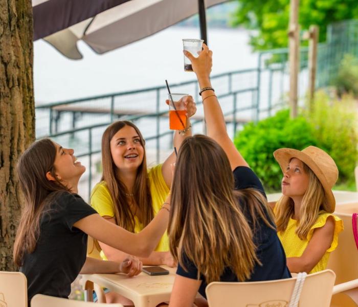 Freundinnen stoßen draußen an einem Sommertag an.